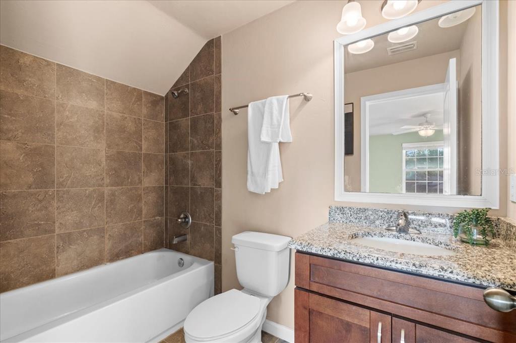 9834 Northwest 17th Road Gainesville, FL 32606 - Photo 31 of 51 a bathroom with a granite countertop toilet a sink and bathtub