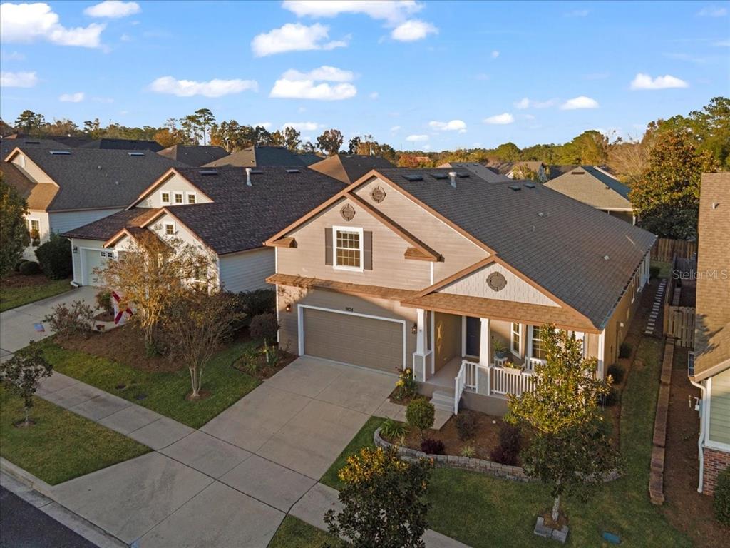 9834 Northwest 17th Road Gainesville, FL 32606 - Photo 47 of 51 a view of a white house next to a yard with big trees
