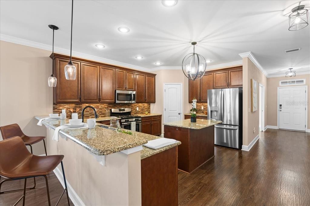 9834 Northwest 17th Road Gainesville, FL 32606 - Photo 5 of 51 a kitchen with a center island wooden floor and stainless steel appliances
