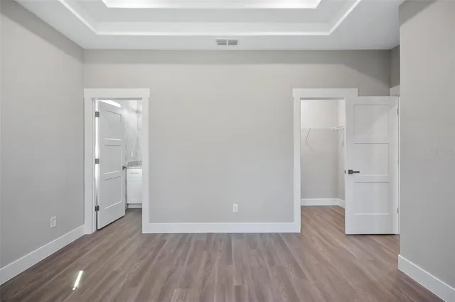 an empty room with wooden floor & closet