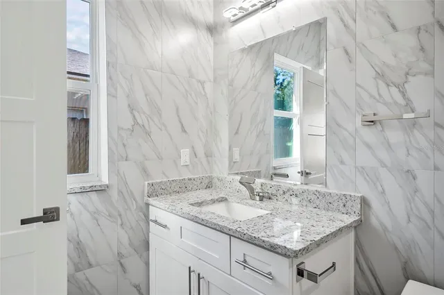 a bathroom with a granite countertop sink and a mirror