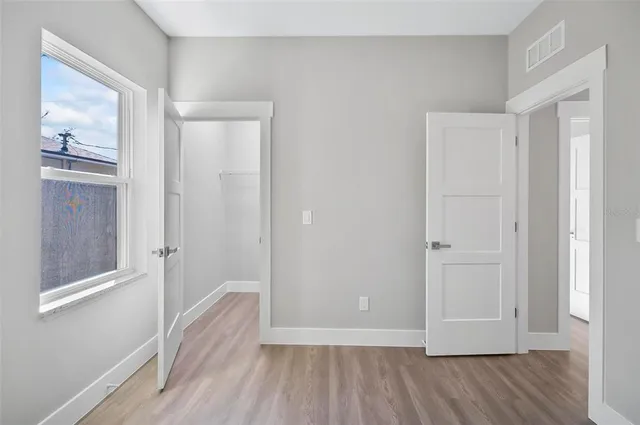 a view of a hallway with wooden floor and closet