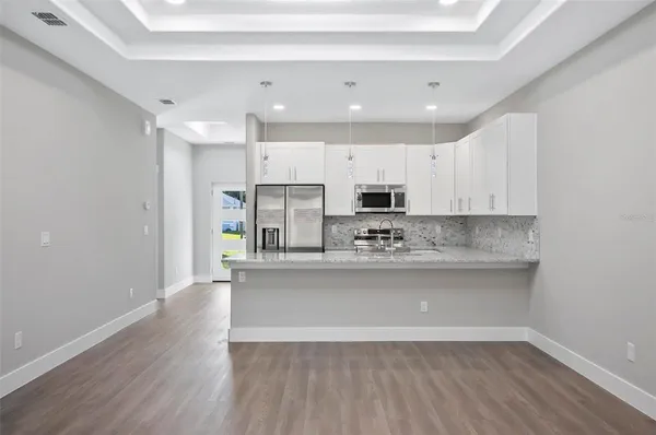 a view of kitchen with granite countertop cabinets and wooden floor