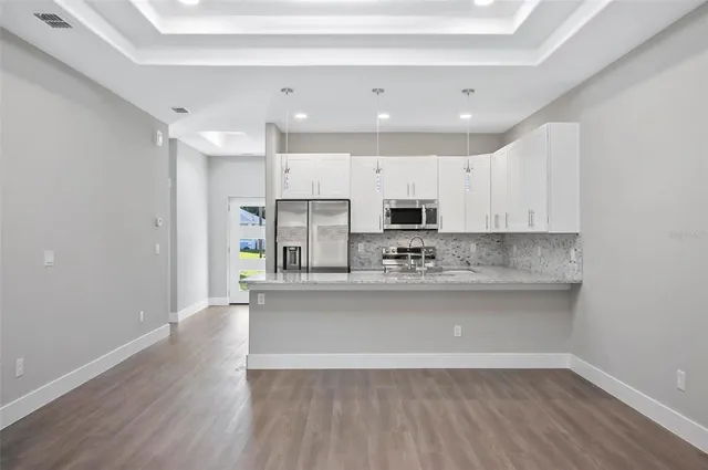 a view of kitchen with granite countertop cabinets and wooden floor