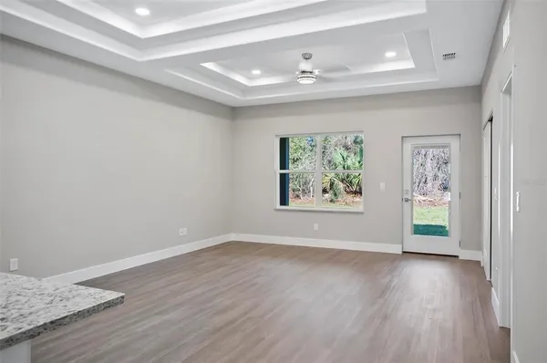 an empty room with wooden floor and window