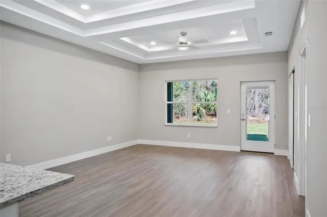 an empty room with wooden floor and window
