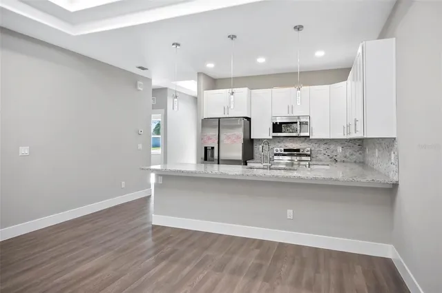 a view of kitchen with granite countertop cabinets and wooden floor