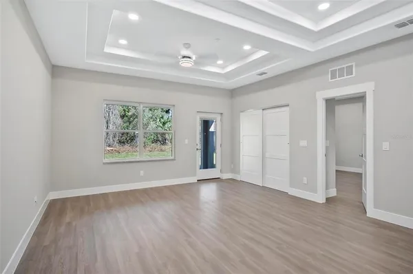 an empty room with wooden floor and window