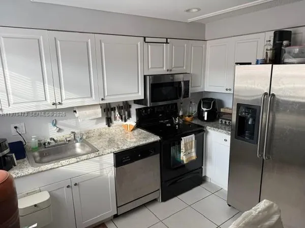 a kitchen with a sink a stove a refrigerator and cabinets
