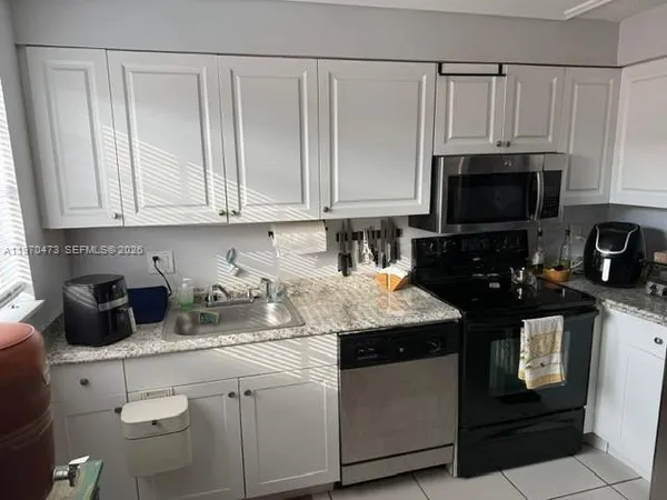 a kitchen with stainless steel appliances granite countertop a sink stove and microwave
