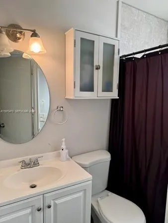 a bathroom with a sink vanity mirror and toilet