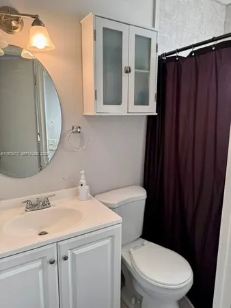 a bathroom with a sink a toilet and a mirror