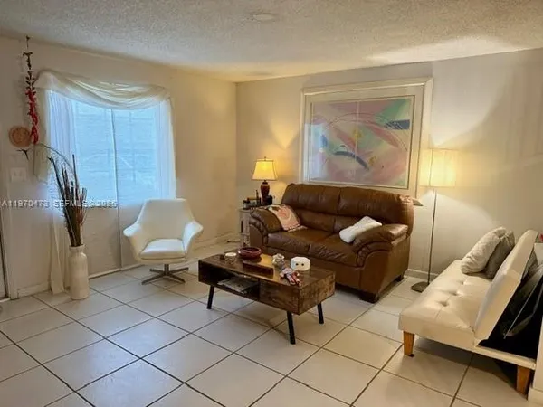a living room with furniture and a painting on the wall