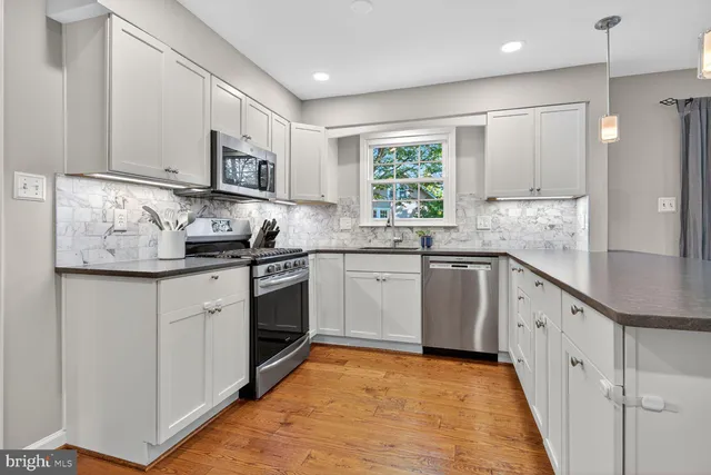 a kitchen with cabinets and wooden floor