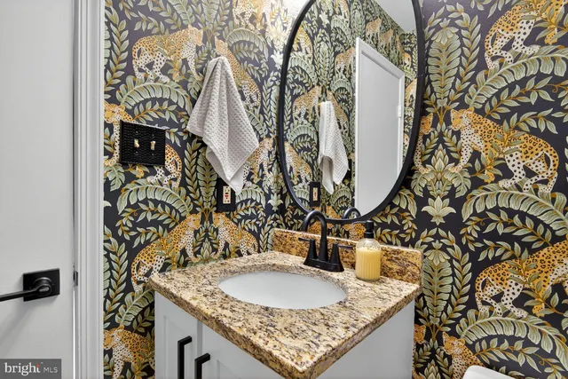 a bathroom with a granite countertop sink and a toilet