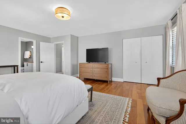 a spacious bedroom with a bed and a flat screen tv