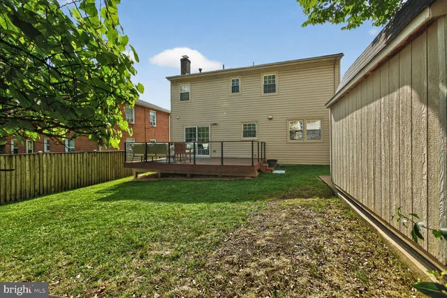 a view of backyard with table and chairs and wooden fence