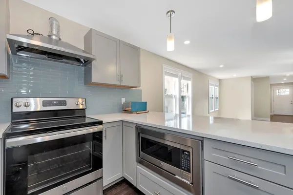 a kitchen that has a sink a stove and a oven