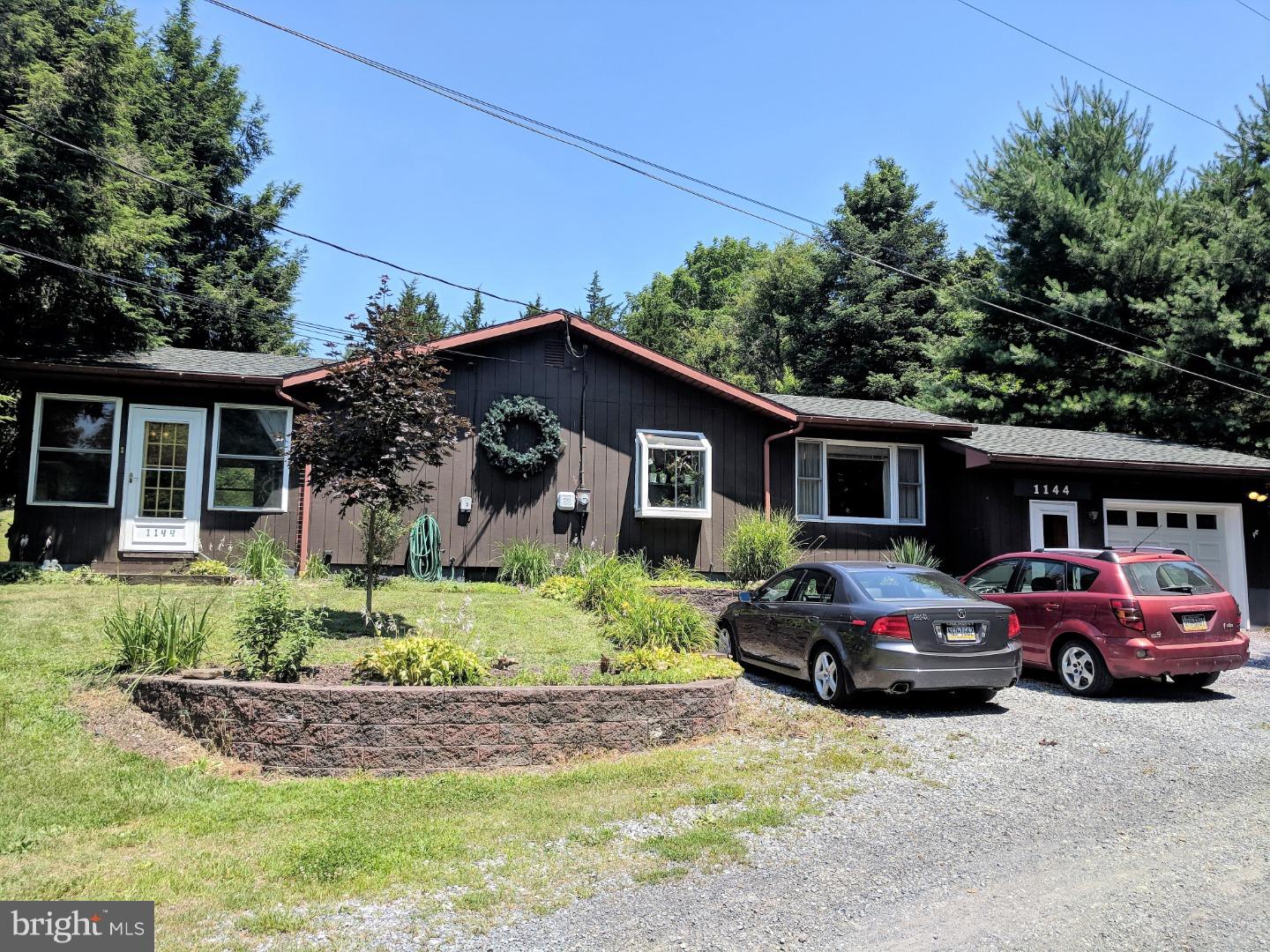 1144 Upper Van Reed Road Leesport, PA 19533 - Photo 2 of 25 a front view of a house with a garden and parking space