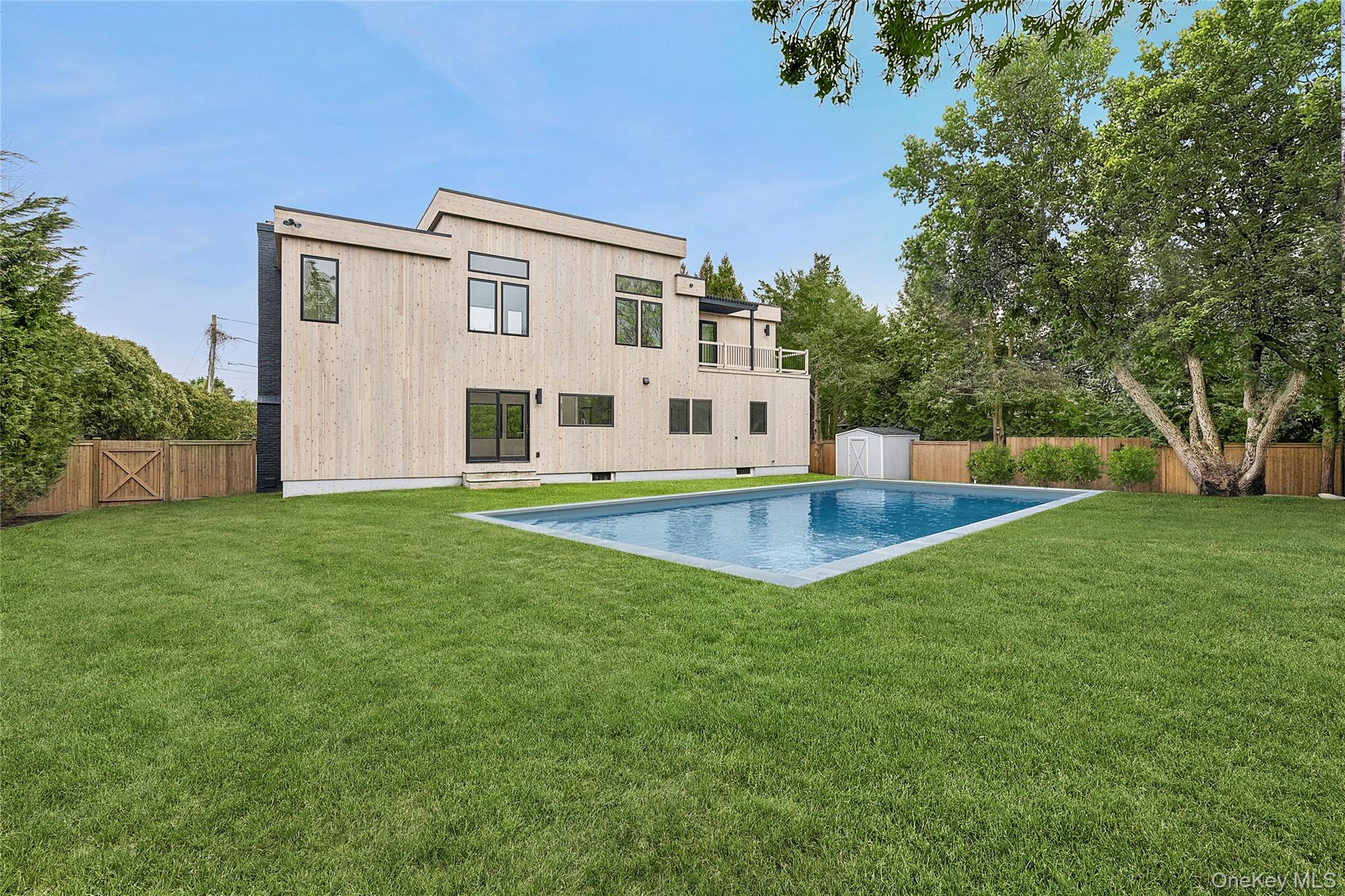 3 Shore Lane Westhampton, NY 11977 - Photo 17 of 17 Rear view of property featuring a patio area, a fenced backyard, and a storage unit