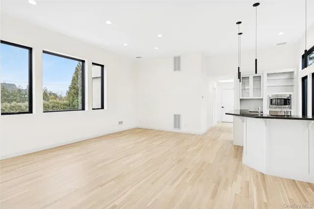 a view of empty room with wooden floor and window