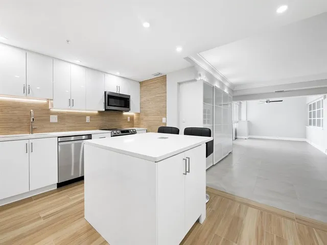 a kitchen with a sink refrigerator and cabinets