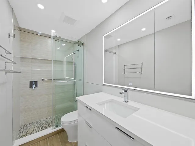 a bathroom with a sink a toilet and shower