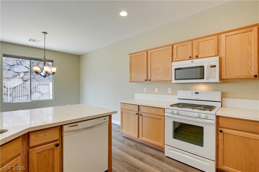 703 Principle Point Avenue Henderson, NV 89012 - Photo 10 of 29 A well-equipped kitchen features solid wood cabinetry, durable countertops, and modern appliances, with a casual dining area.
