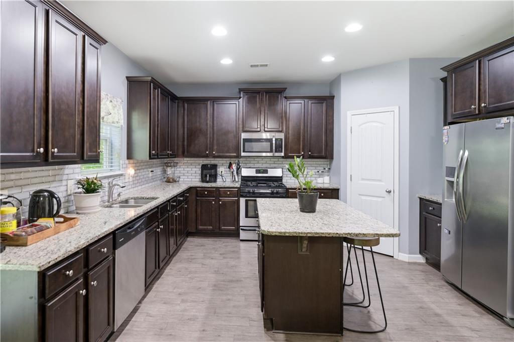 291 Boulder Run Hiram, GA 30141 - Photo 13 of 46 a kitchen with kitchen island granite countertop a sink counter top space appliances and cabinets