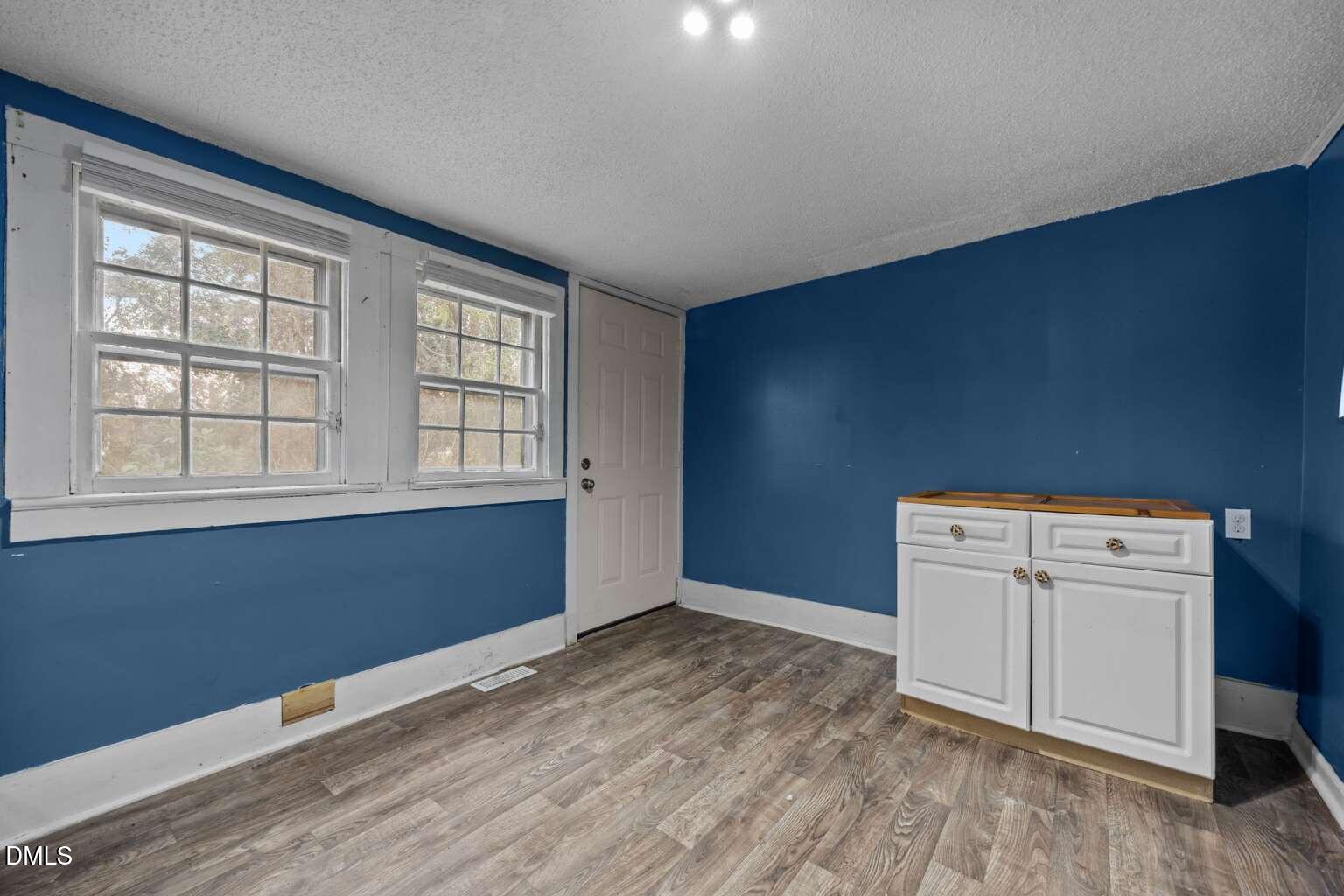 2821 Old Fairground Road Angier, NC 27501 - Photo 11 of 32 an empty room with wooden floor and windows