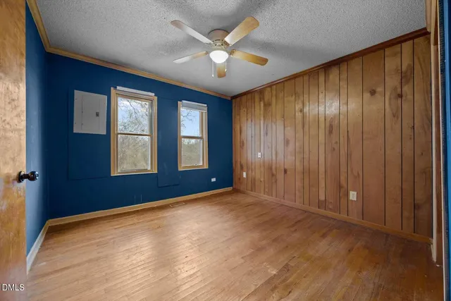 an empty room with windows and a ceiling fan