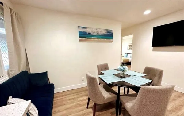 a kitchen with a dining table chairs and a refrigerator