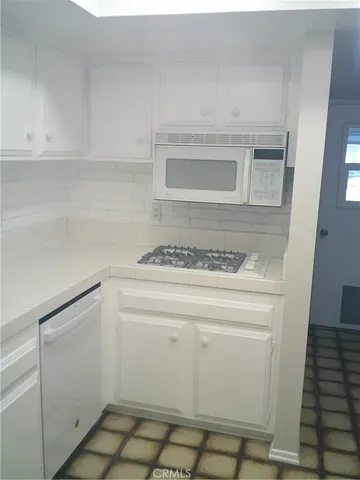 a utility room with cabinets washer and dryer