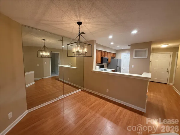 a view of a livingroom with a fireplace a ceiling fan and wooden floor