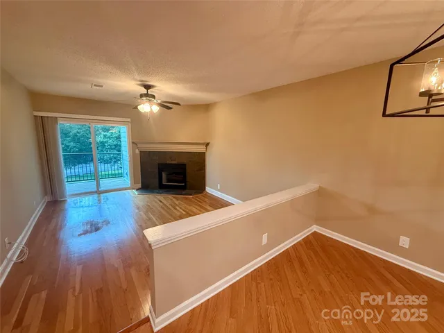 a view of an empty room with a fireplace and a window