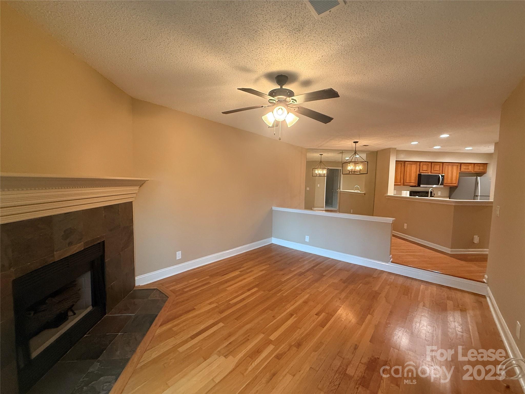 18801 Nautical Drive, Unit 203 Cornelius, NC 28031 - Photo 19 of 28 a view of a livingroom with a fireplace a ceiling fan and wooden floor