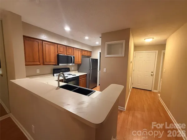 a kitchen with stainless steel appliances wooden cabinets and a stove top oven