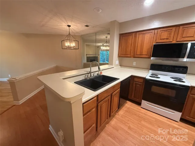 a kitchen with stainless steel appliances a stove a refrigerator and a microwave