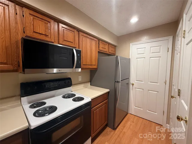 a kitchen with stainless steel appliances wooden cabinets and a stove top oven