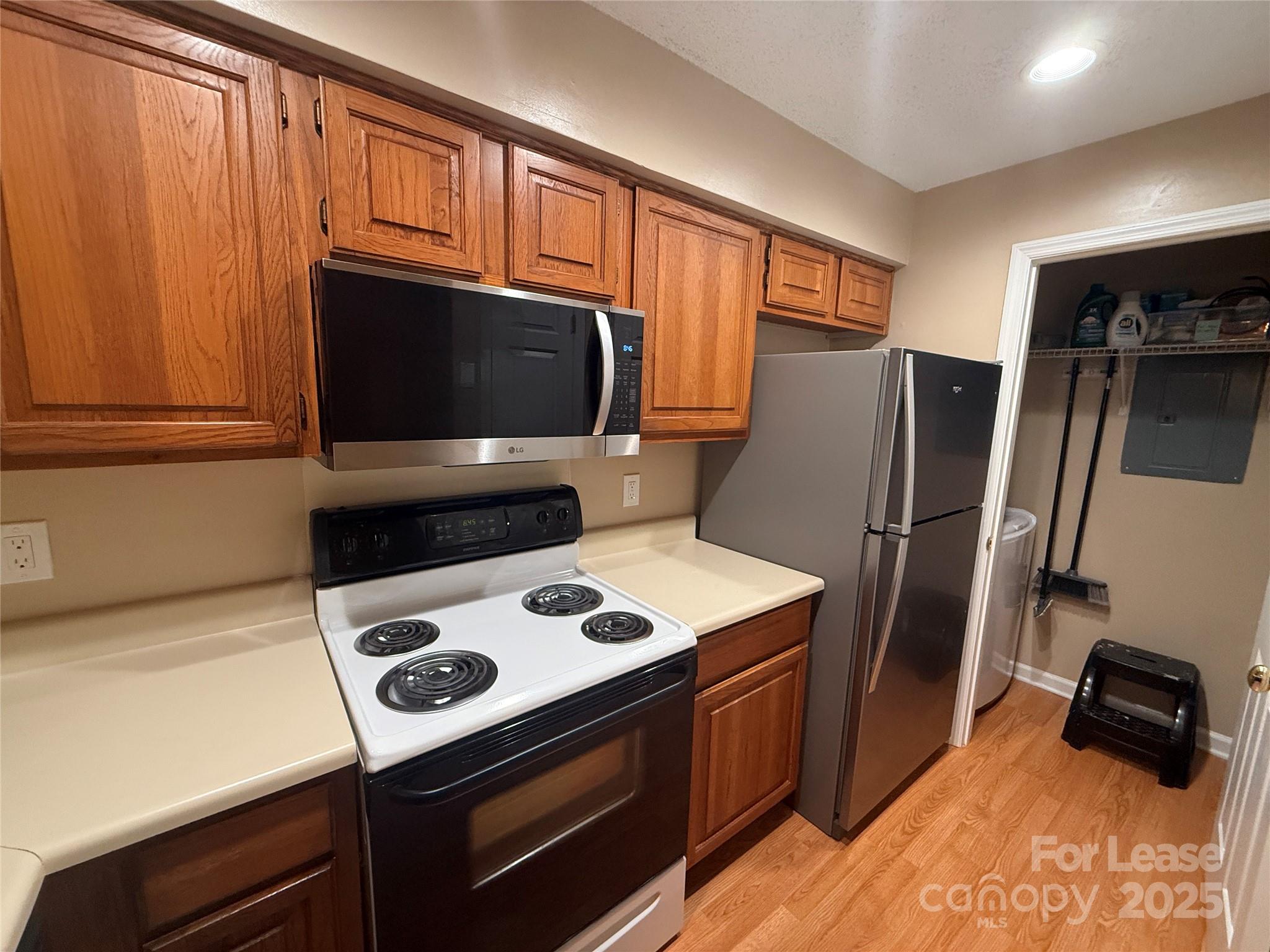 18801 Nautical Drive, Unit 203 Cornelius, NC 28031 - Photo 10 of 28 a kitchen with stainless steel appliances wooden cabinets and a stove top oven