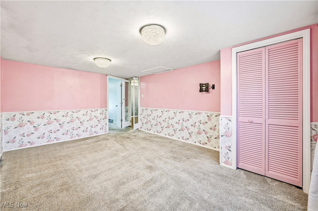 245 North Road Niles, OH 44446 - Photo 25 of 45 Carpeted spare room featuring a textured ceiling, wallpapered walls, and wainscoting