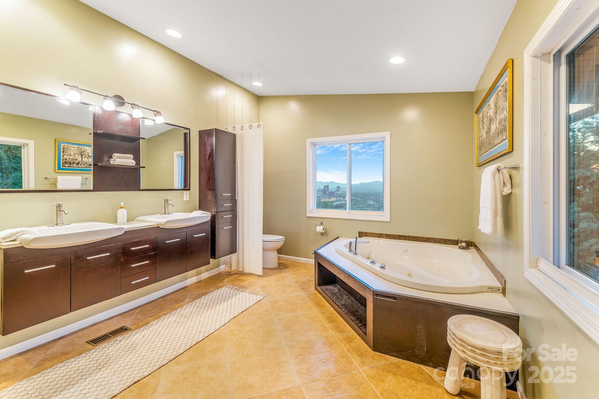 19 Westview Road Asheville, NC 28804 - Photo 33 of 44 a spacious bathroom with a double vanity sink a large mirror and a bathtub