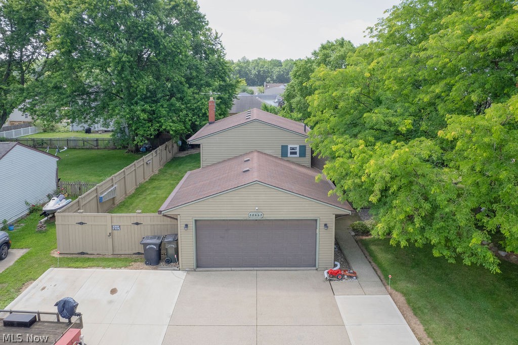 38667 Chestnut Ridge Road Elyria, OH 44035 - Photo 2 of 35 Split level residence featuring light-colored siding, a two-car garage with a brown door, and a private fenced yard