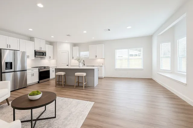 a kitchen with a dining table chairs and refrigerator