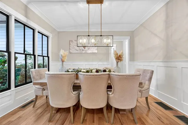 a view of a dining room with furniture a chandelier and wooden floor