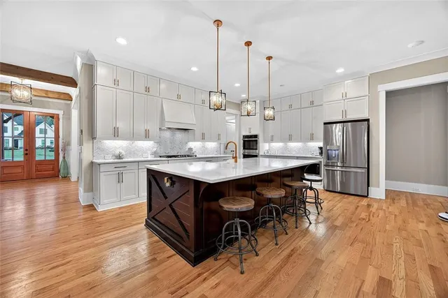 a kitchen with kitchen island a wooden floor and white appliances