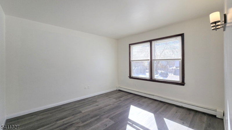 388 Garibaldi Avenue Lodi, NJ 07644 - Photo 11 of 20 an empty room with wooden floor and windows