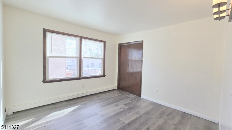 388 Garibaldi Avenue Lodi, NJ 07644 - Photo 13 of 20 an empty room with wooden floor and windows