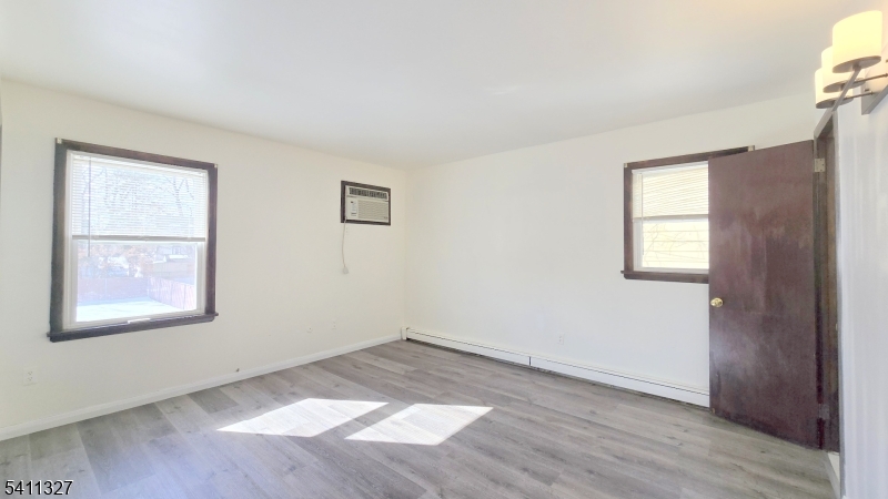 388 Garibaldi Avenue Lodi, NJ 07644 - Photo 15 of 20 an empty room with wooden floor and windows
