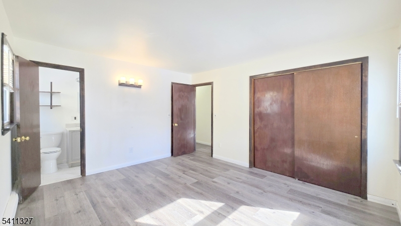 388 Garibaldi Avenue Lodi, NJ 07644 - Photo 16 of 20 a view of an empty room with wooden floor and a bathroom